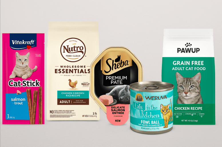 Five cat food products including Vitakraft Cat Stick, Nutro Wholesome Essentials, Sheba Premium Pate, Weruva Cats in the Kitchen, and PAWUP Grain-Free Cat Food displayed side by side.