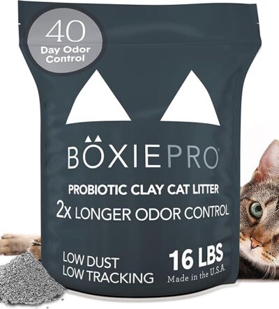A bag of BoxiePro Probiotic Clay Cat Litter with a cat in the background and a small pile of litter in the foreground. The bag is dark grey with white text that reads "BöxiePro Probiotic Clay Cat Litter 2x Longer Odor Control 16 LBS Low Dust Low Tracking Made in the U.S.A." and a circle at the top saying "40 Day Odor Control.